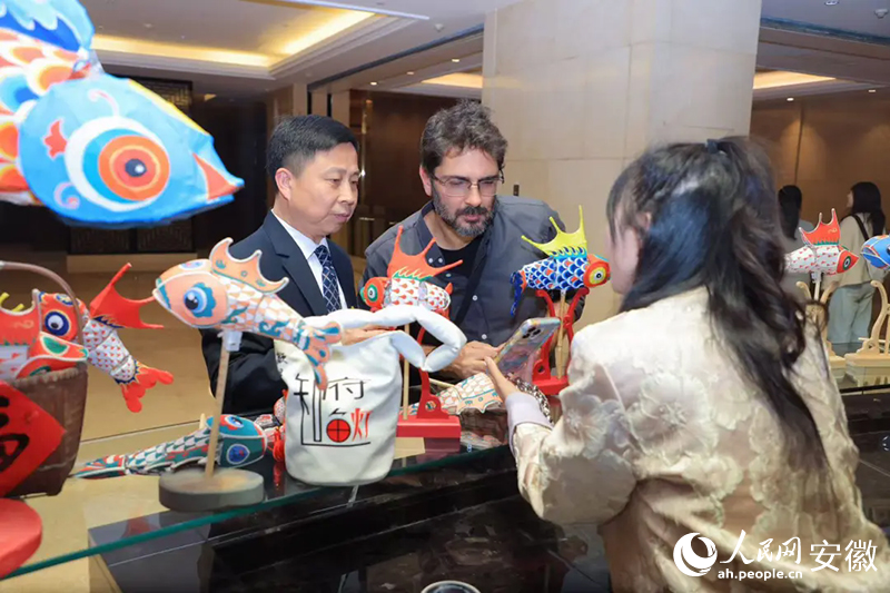 巴西旅行商米內維諾·奧爾蒂斯·內托·西爾維里奧（中）對魚燈充滿好奇。人民網記者 王曉飛攝